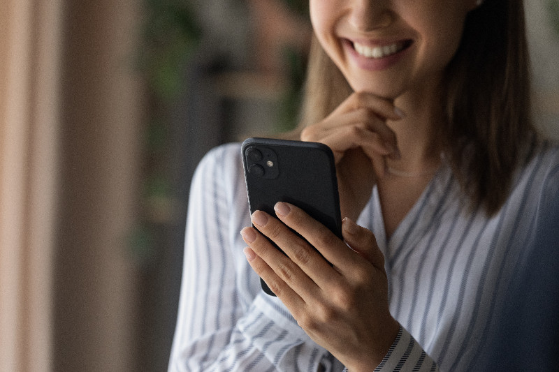 Woman smiling while looking at her phone