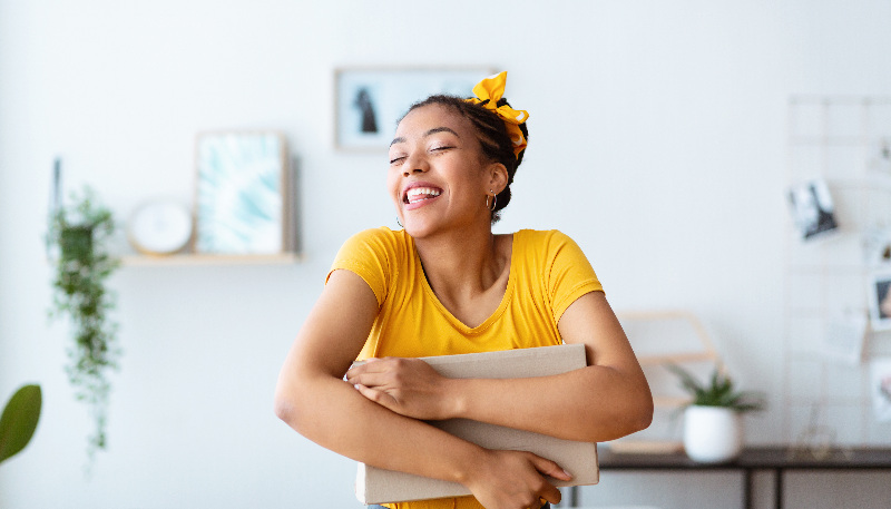 A woman smiling and hugging her parcel